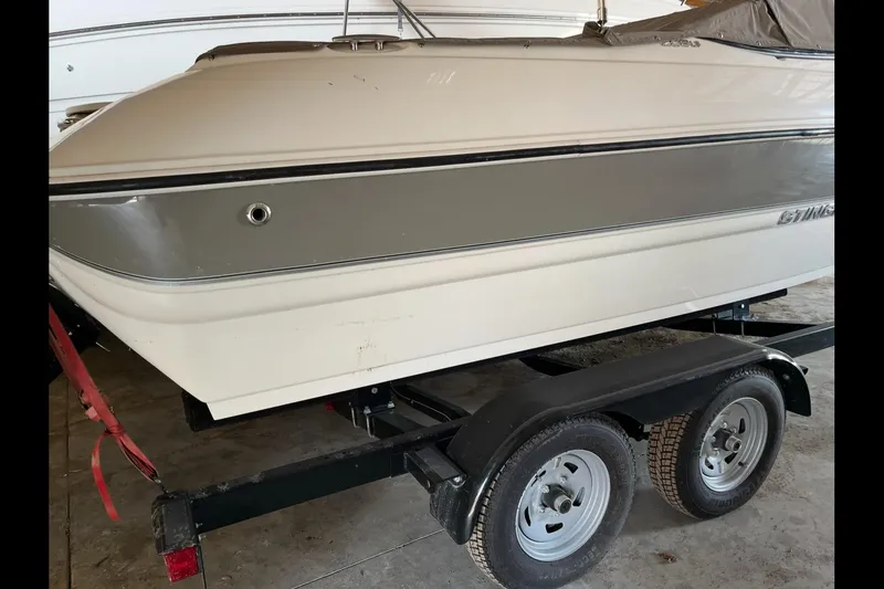 Slide: The Image of 2019 Stingray 208 LS boat on trailer in garage setting. - 7
