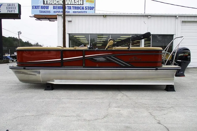 Slide: The Image of 2026 SunCatcher Fusion 322RC pontoon boat displayed outdoors near a service center. - 6