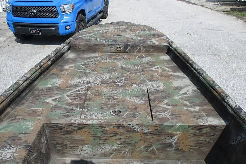 Slide: The Image of Camouflage-patterned G3 Gator Tough 16 DK boat, 2026 model, parked near a blue truck. - 13