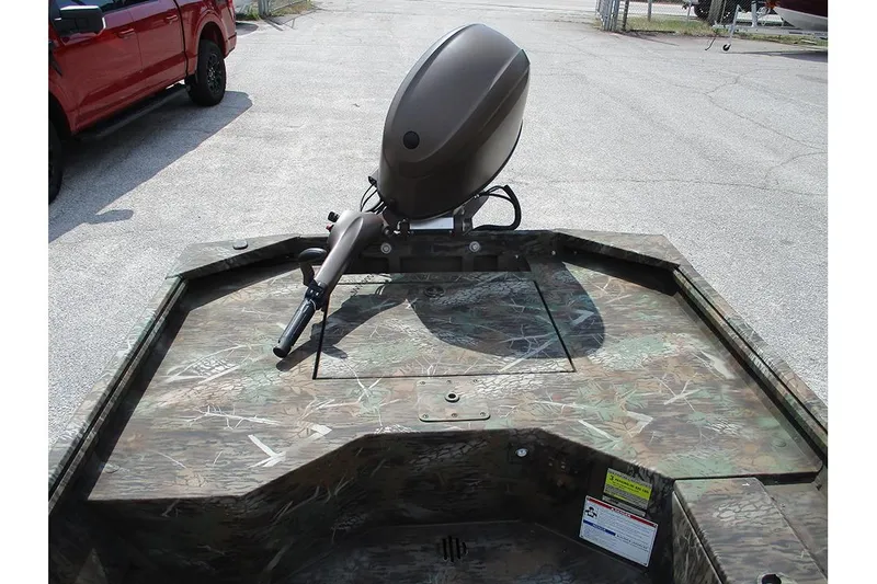 Slide: The Image of 2026 G3 Gator Tough 16 DK boat with camouflage design and motor, parked outdoors. - 9