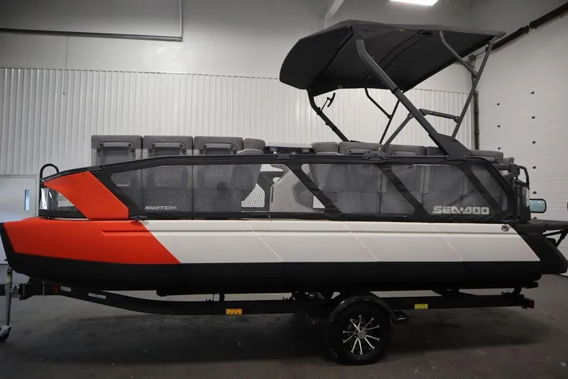 Slide: The Image of 2024 Sea-Doo Switch Cruise 21 pontoon boat with canopy in indoor setting. - 11