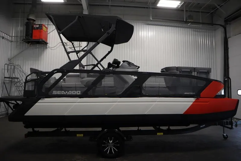 Slide: The Image of 2024 Sea-Doo Switch Cruise 21 pontoon boat in a showroom, side view. - 4