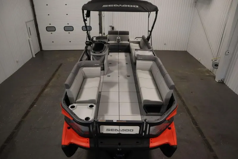 Slide: The Image of 2024 Sea-Doo Switch Cruise 21 pontoon boat with spacious seating in a garage setting. - 6