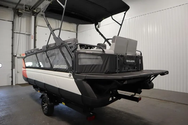 Slide: The Image of 2024 Sea-Doo Switch Cruise 21 pontoon boat in indoor storage, rear view. - 9