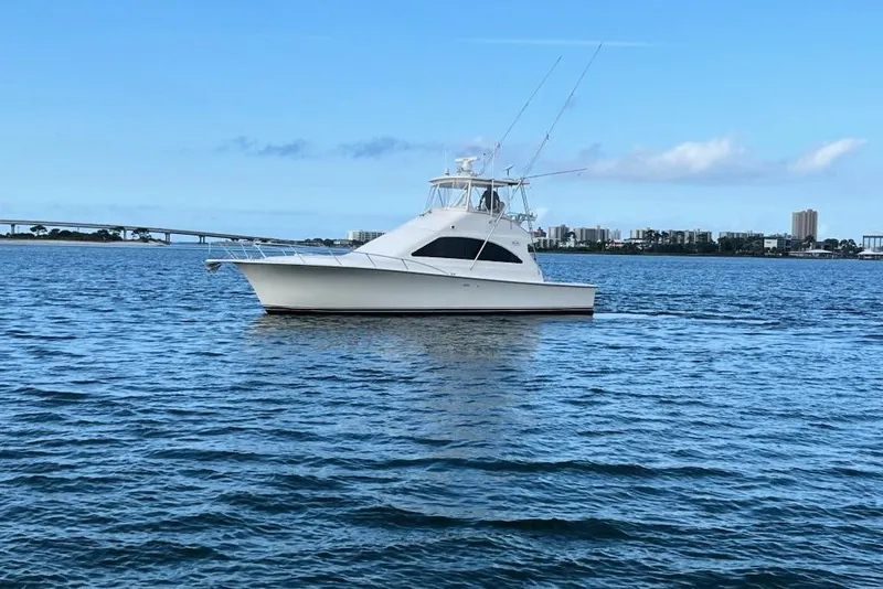 Slide: The Image of 2001 Ocean Yachts 43 Super Sport cruising on calm waters with city skyline backdrop. - 2