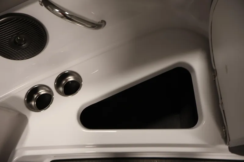 Slide: The Image of Interior detail of 2026 Four Winns H1 OB boat, featuring cup holders and storage compartment. - 15