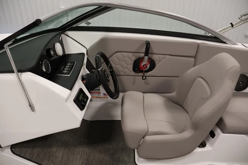 Slide: The Image of 2026 Four Winns H1 OB boat interior with steering wheel and beige seating. - 16
