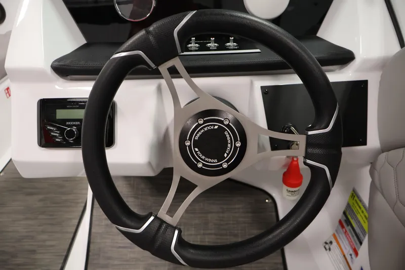 Slide: The Image of Steering wheel of 2026 Four Winns H1 OB boat, featuring modern controls and sleek design. - 18