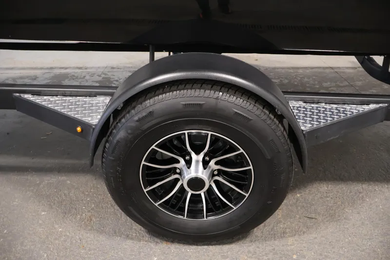 Slide: The Image of Trailer wheel of 2026 Four Winns H1 OB boat, featuring sleek black alloy rim. - 43