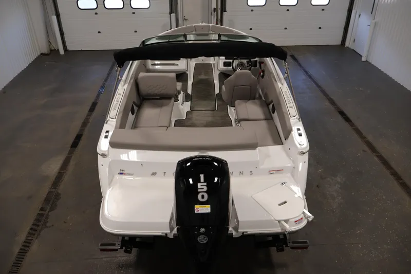 Slide: The Image of 2026 Four Winns H1 OB boat in a garage, showcasing interior seating and outboard motor. - 9