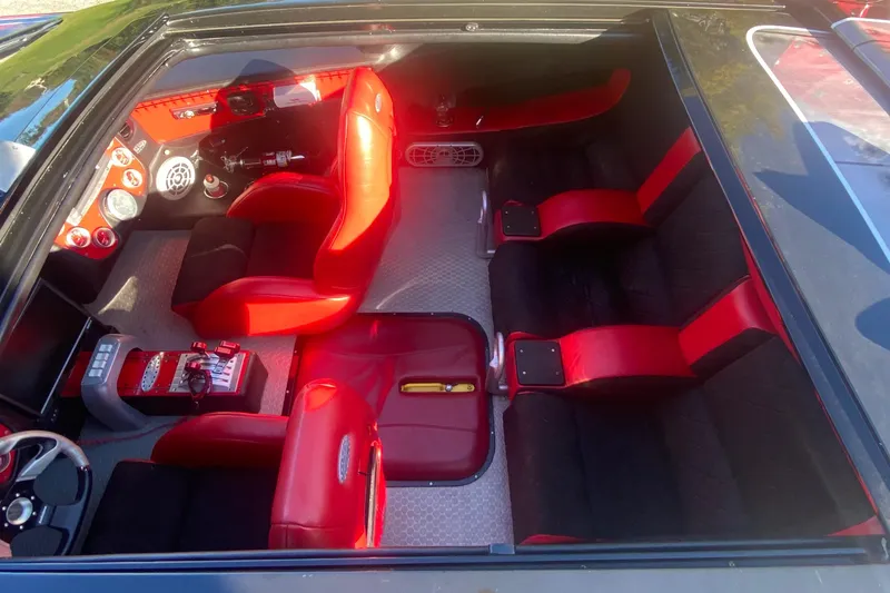 Slide: The Image of 2007 Nor-Tech 4700 Super Cat interior with red and black seating, sleek dashboard design. - 12