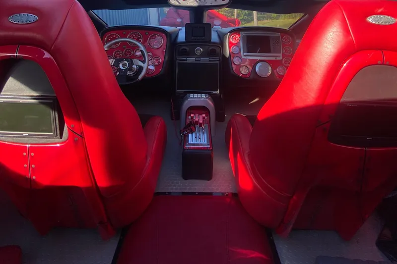 Slide: The Image of Interior of a 2007 Nor-Tech 4700 Super Cat with vibrant red seating and dashboard. - 13