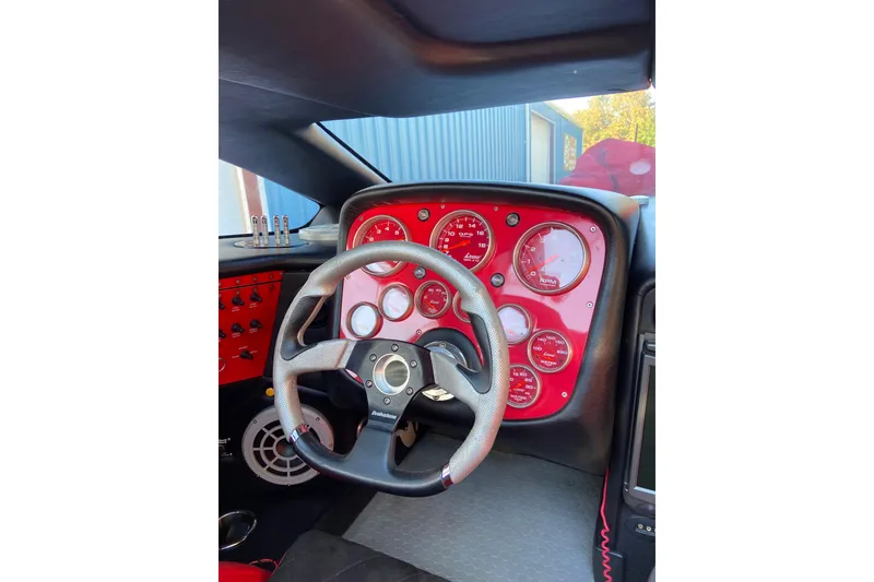 Slide: The Image of Dashboard of a 2007 Nor-Tech 4700 Super Cat with red gauges and steering wheel. - 14