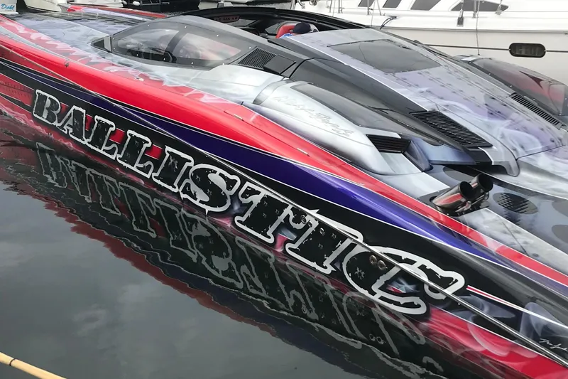 Slide: The Image of 2007 Nor-Tech 4700 Super Cat speedboat with vibrant red and blue design, docked in water. - 7