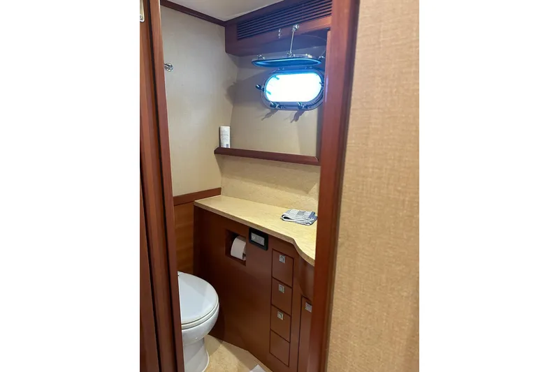 Slide: The Image of Bathroom interior of 2016 Nordhavn 60 yacht with wooden cabinetry and porthole window. - 16