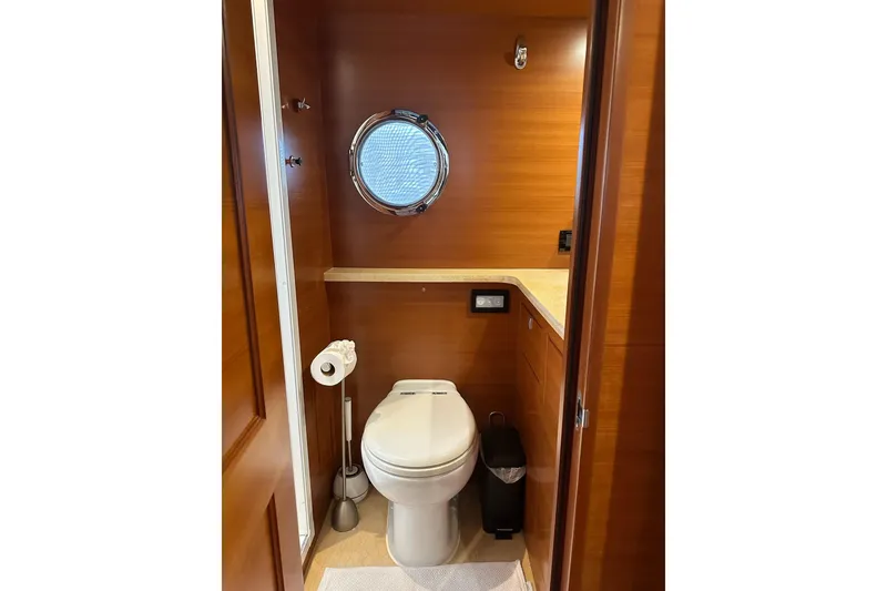 Slide: The Image of Luxurious 2016 Nordhavn 60 yacht bathroom with wooden paneling and porthole window. - 22