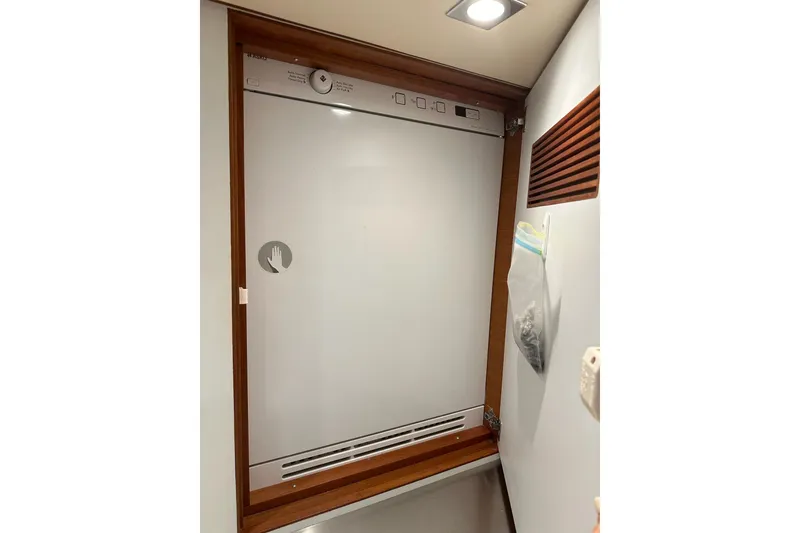 Slide: The Image of Laundry area inside 2016 Nordhavn 60 yacht, featuring a built-in dryer. - 26