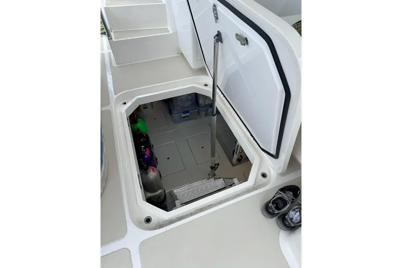 Slide: The Image of Open hatch on 2016 Nordhavn 60 yacht deck, revealing storage area with scuba tanks. - 37