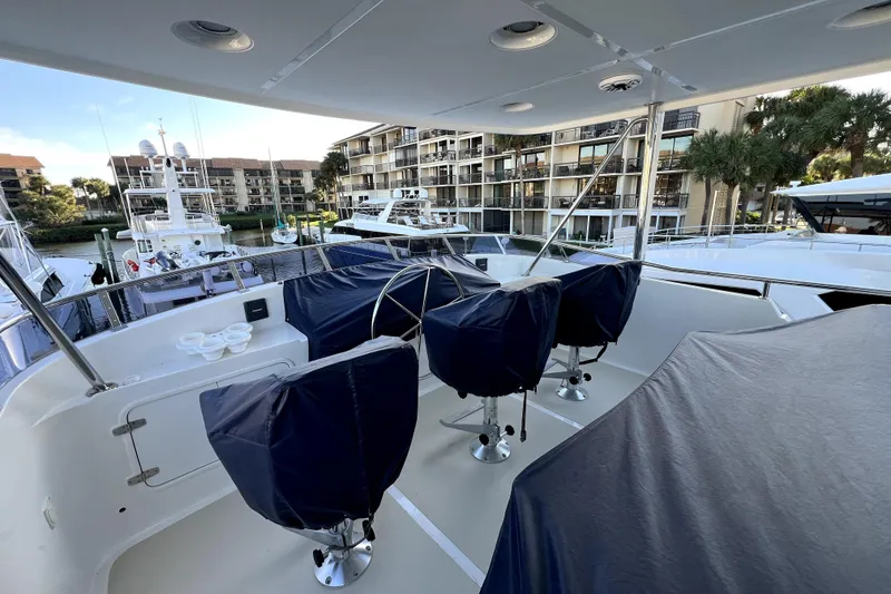 Slide: The Image of 2016 Nordhavn 60 yacht deck with covered seating, docked near waterfront buildings. - 7