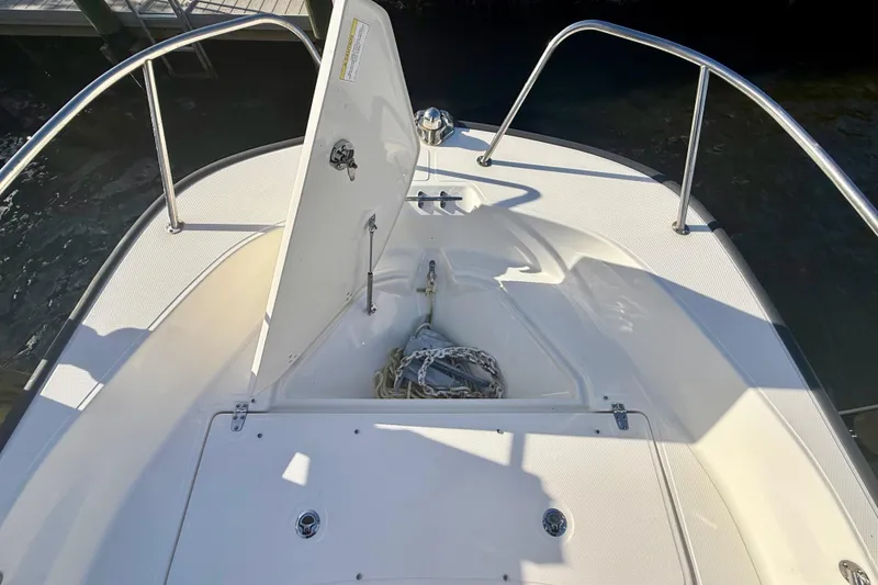 Slide: The Image of 2025 Boston Whaler 170 Montauk boat deck with open storage compartment and anchor. - 3