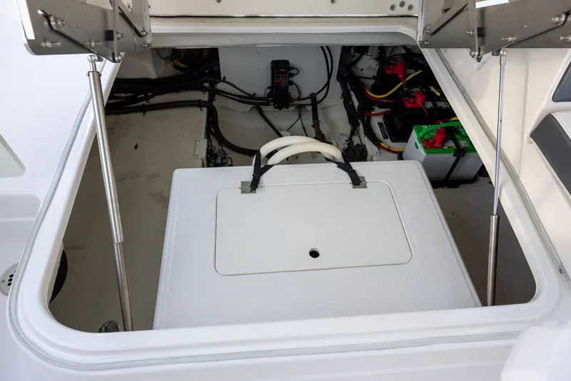 Slide: The Image of 2021 Chaparral 280 OSX boat storage compartment with visible wiring and battery setup. - 19