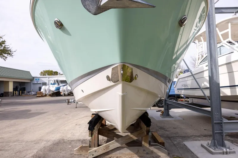 Slide: The Image of 2021 Chaparral 280 OSX boat on a stand, front view, in a marina setting. - 3