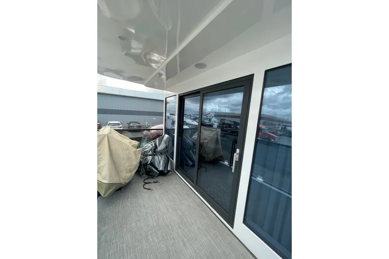 Slide: The Image of Modern 2025 Houseboat ALLHOUSE HB-1250 with sleek glass doors and covered outdoor area. - 21