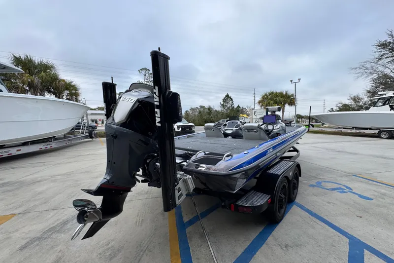 Slide: The Image of 2023 Phoenix 21 PHX boat with powerful engine, parked outdoors on a trailer. - 12