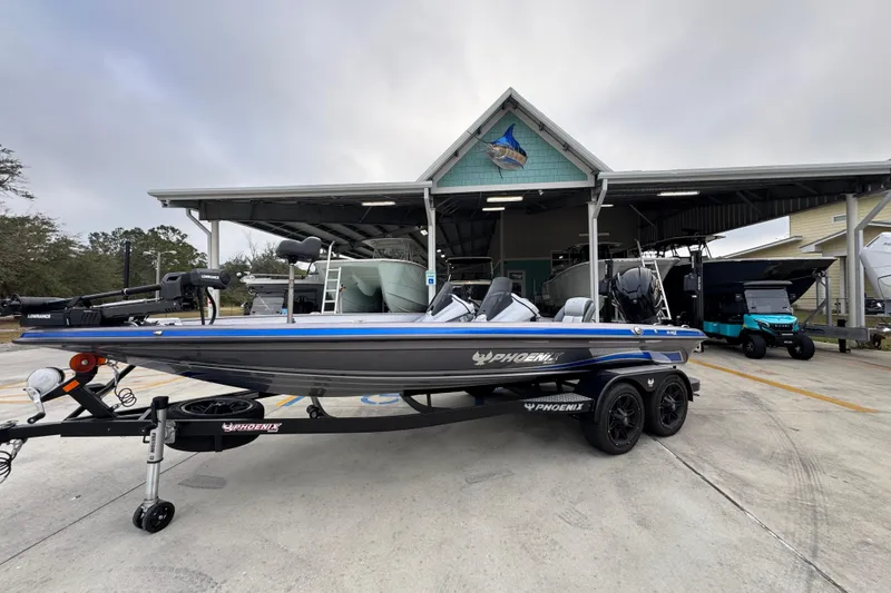 Slide: The Image of 2023 Phoenix 21 PHX boat on trailer at dealership, showcasing sleek design and modern features. - 2