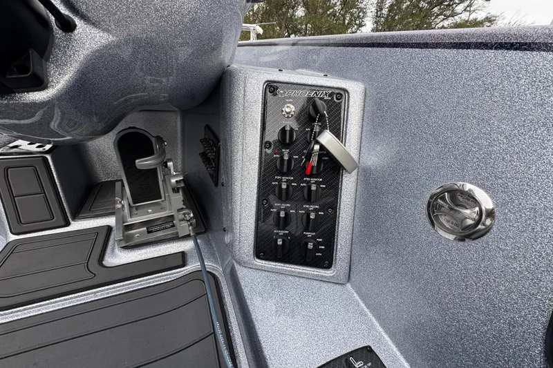 Slide: The Image of 2023 Phoenix 21 PHX boat dashboard with control panel and metallic finish. - 28