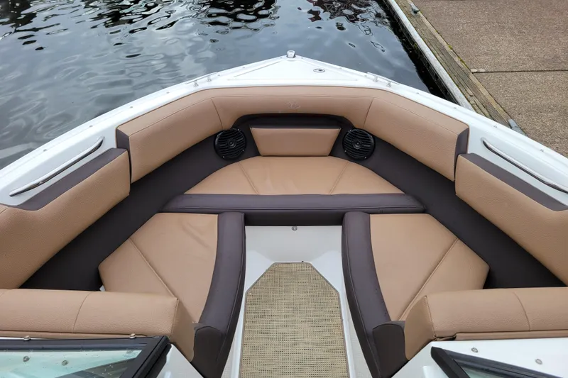 Slide: The Image of 2019 Cobalt CS22 boat interior with tan and brown seating, docked by the water. - 13