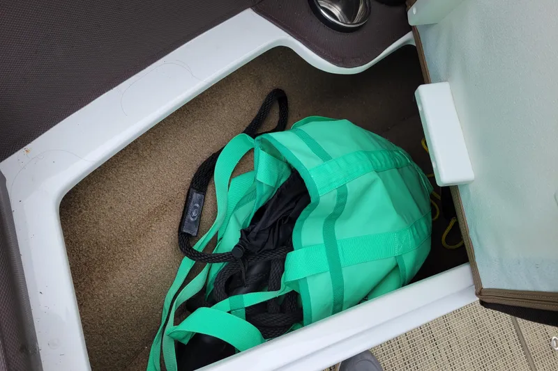 Slide: The Image of Storage compartment in 2019 Cobalt CS22 boat with a teal bag inside. - 19