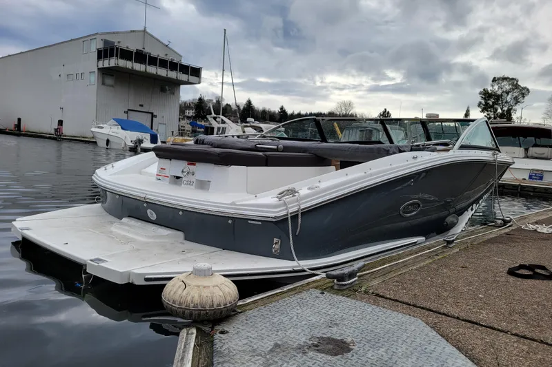 Slide: The Image of 2019 Cobalt CS22 boat docked at a marina under cloudy skies. - 2