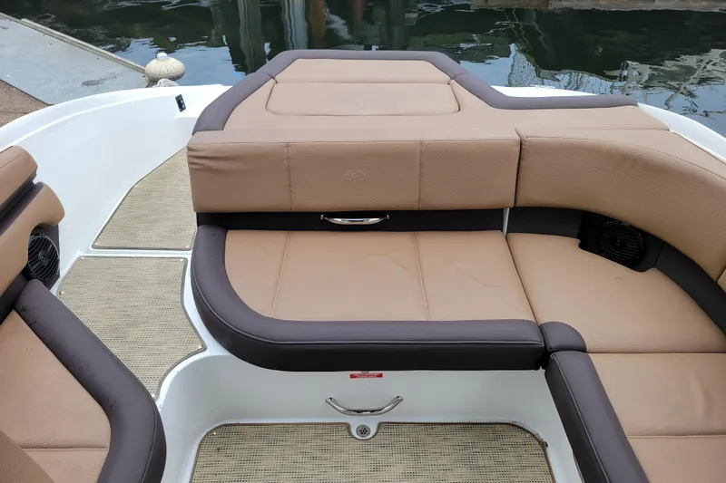 Slide: The Image of 2019 Cobalt CS22 boat interior with tan and brown seating, docked by the water. - 22