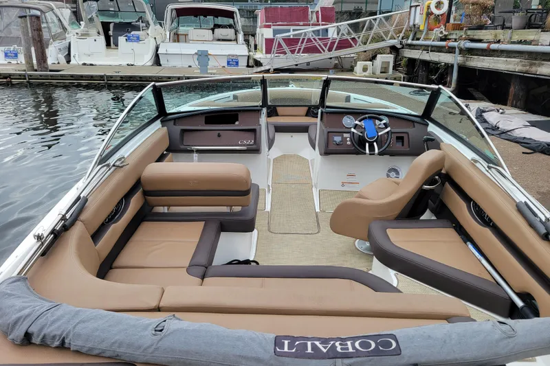 Slide: The Image of 2019 Cobalt CS22 boat interior with tan seating, docked at marina. - 4