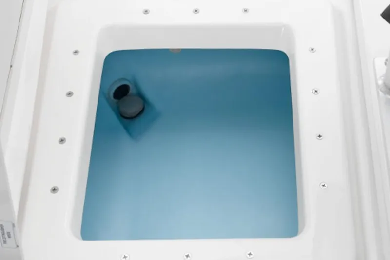 Slide: The Image of Livewell compartment of 2026 Yamaha Boats 190 FSH Sport, featuring a clean, white interior. - 8