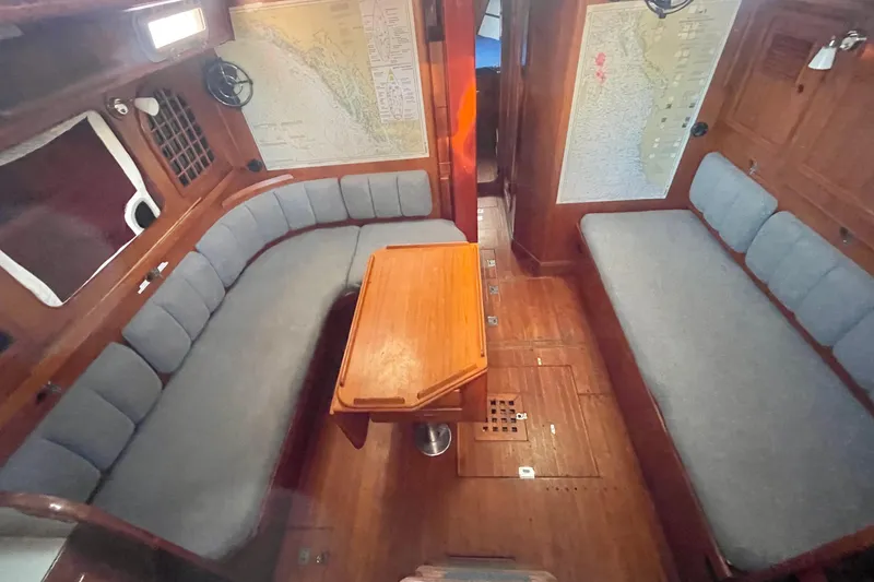 Slide: The Image of Interior of a 1982 Stevens cutter sailboat with wooden furnishings and cushioned seating. - 11
