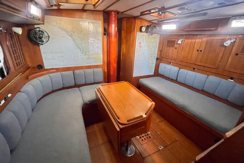 Slide: The Image of Interior of a 1982 Stevens cutter sailboat with wooden furnishings and seating. - 12