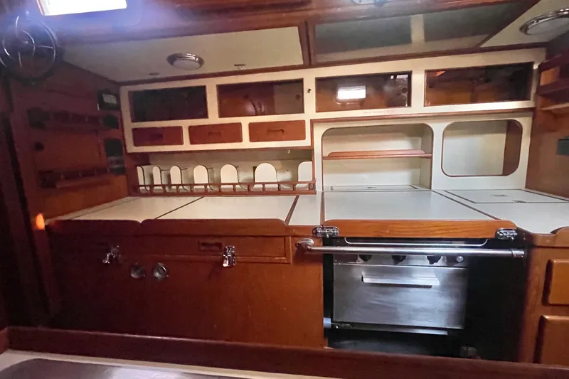 Slide: The Image of 1982 Stevens cutter yacht interior with wooden cabinetry and built-in stove. - 18