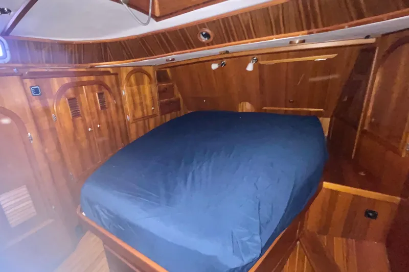 Slide: The Image of Wood-paneled cabin interior of 1982 Stevens cutter with blue-covered bed. - 20