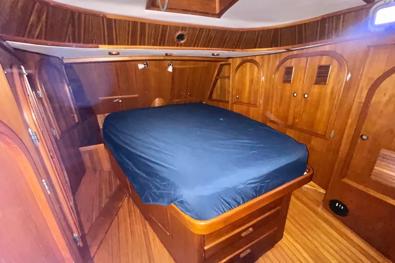 Slide: The Image of Luxurious wooden cabin interior of a 1982 Stevens cutter yacht with a cozy bed. - 21
