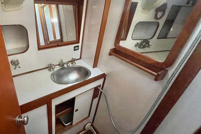 Slide: The Image of 1982 Stevens cutter yacht bathroom with sink, mirror, and wooden accents. - 23
