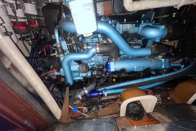 Slide: The Image of Engine compartment of a 1982 Stevens cutter, featuring blue pipes and mechanical components. - 27