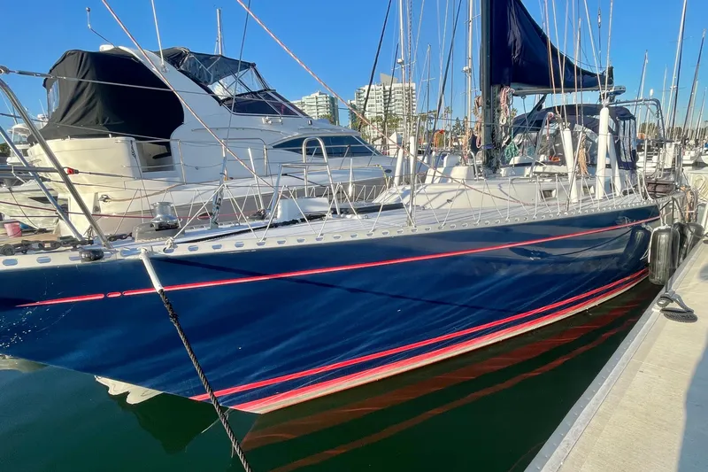 Slide: The Image of 1982 Stevens cutter sailboat docked in marina, blue hull with red stripe, clear sky. - 4