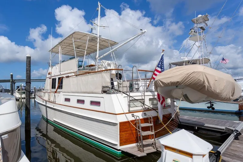 Slide: The Image of 1993 Grand Banks 46 Motoryacht docked, featuring classic design and American flag. - 1