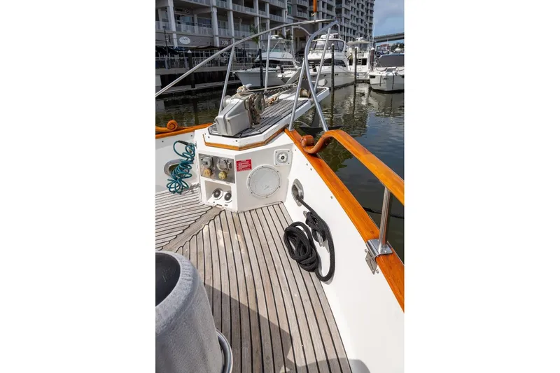 Slide: The Image of Side deck of 1993 Grand Banks 46 Motoryacht, featuring wooden railings and docked boats. - 16