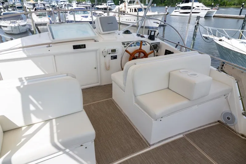 Slide: The Image of 1993 Grand Banks 46 Motoryacht helm with white seating and navigation equipment at marina. - 27