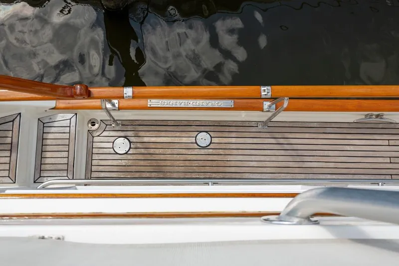 Slide: The Image of Deck view of 1993 Grand Banks 46 Motoryacht with wooden railings and water reflection. - 37