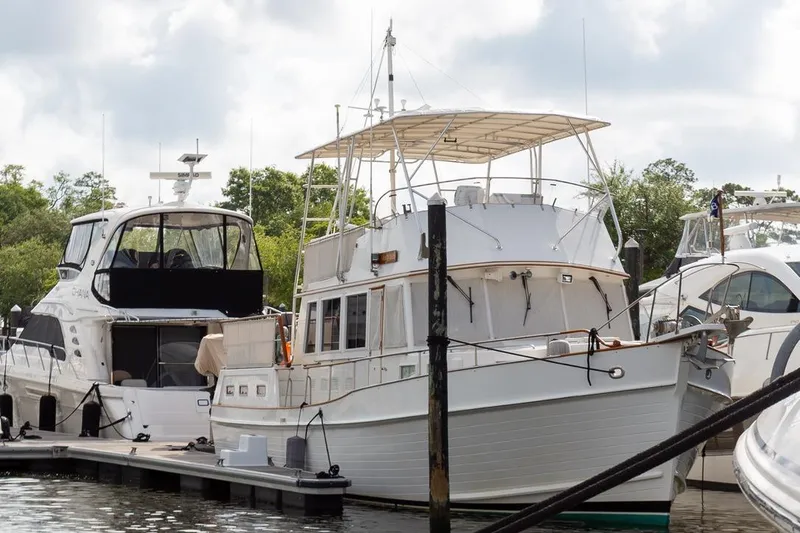 Slide: The Image of 1993 Grand Banks 46 Motoryacht docked at marina, surrounded by other boats. - 4