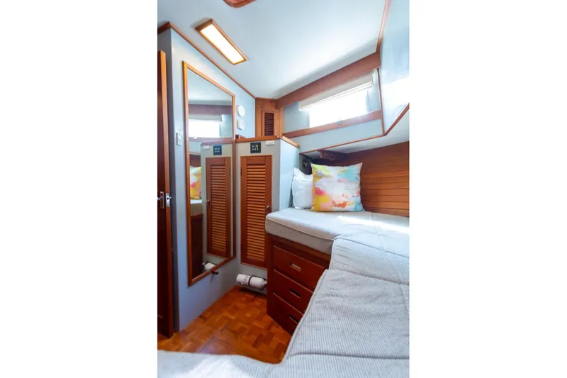 Slide: The Image of 1993 Grand Banks 46 Motoryacht cabin interior with wooden finishes and colorful pillows. - 45